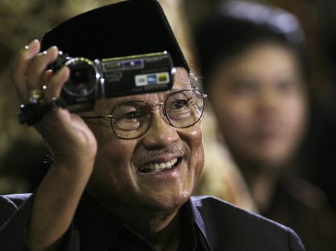 FILE - In this Nov. 10, 2010, file pool photo, former Indonesian President B.J. Habibie films the crowd as he sits in the audience to hear U.S. President Barack Obama's speech at the University of Indonesia, in Jakarta, Indonesia. Habibie, who allowed democratic reforms and an independence referendum for East Timor following the ouster of the dictator Suharto, has died at age 83. (Barbara Walton, Pool Photo via AP, File)