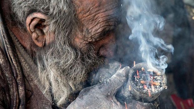 Amou Haji merokok dari pipa saat dia duduk di tanah di pinggiran desa Dezhgah di distrik Dehram di provinsi Fars Iran barat daya, Jumat (28/12/2018). Amou Haji itu dijuluki sebagai 